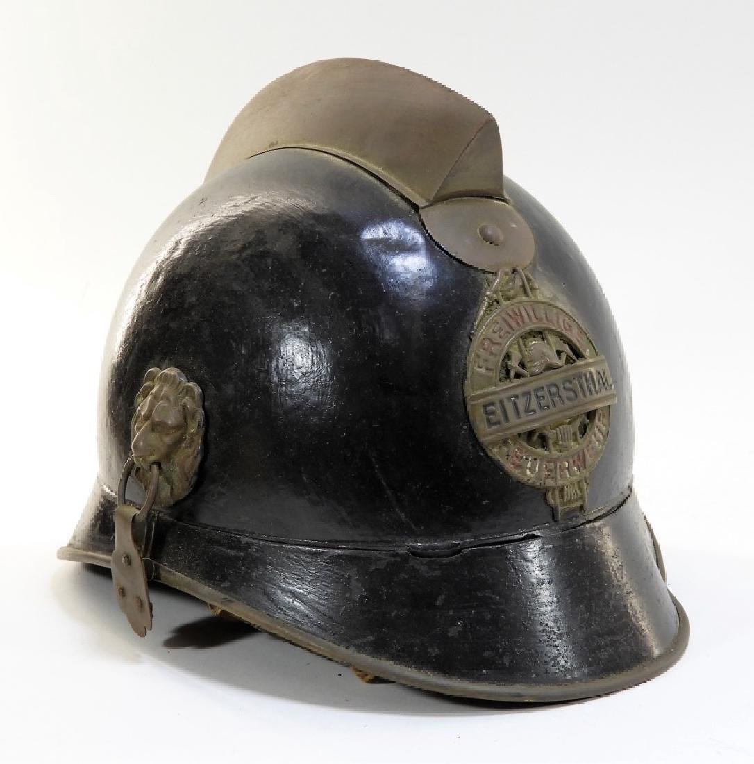 Bavarian Brass Mounted Fireman's Helmet: GERMANY, EARLY 20TH CENTURY An antique Bavarian brass mounted fire fighter's helmet. The helmet is trimmed with figural molded lion's head ring handles for a chin strap. Dimensions : 10" long by 7" wi