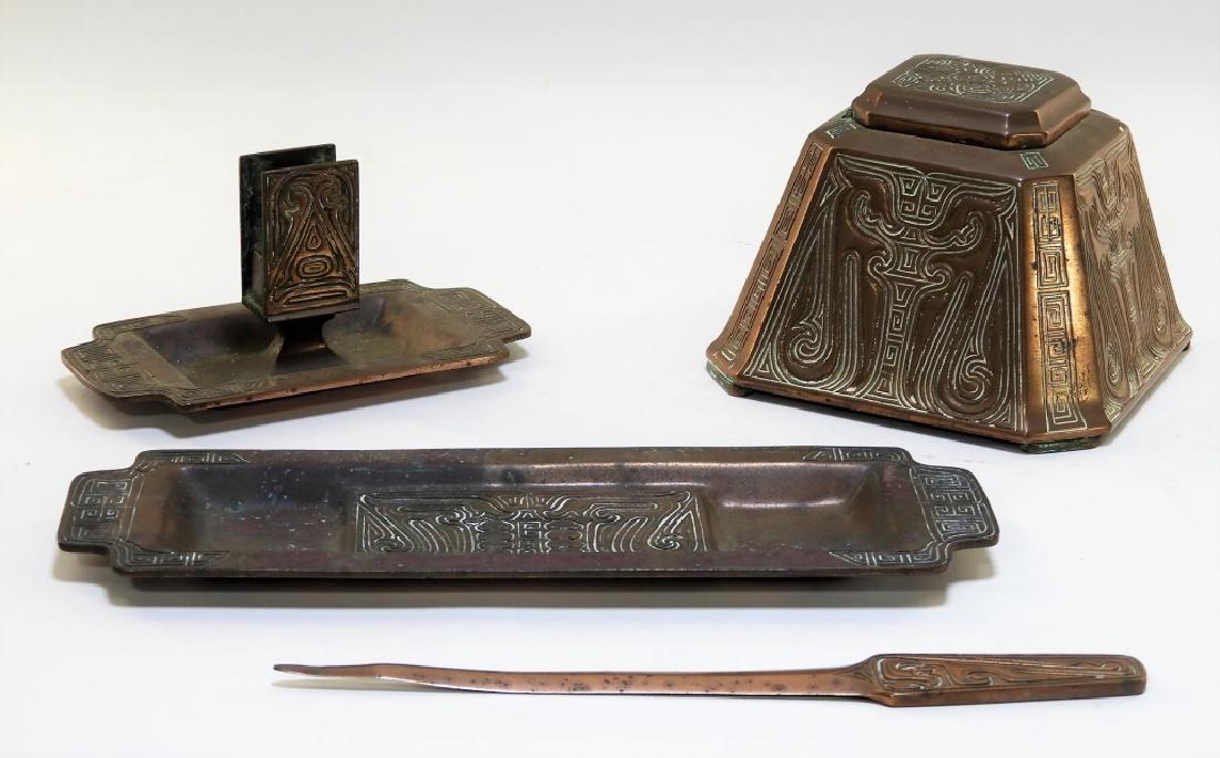 4PC Tiffany Studios Chinese Bronze Desk Set: UNITED STATES, CIRCA 1910 A four piece Tiffany Studios patinated bronze Chinese pattern desk set. The set includes an inkwell with glass insert, letter opener, desk tray, and card holder decorated in 