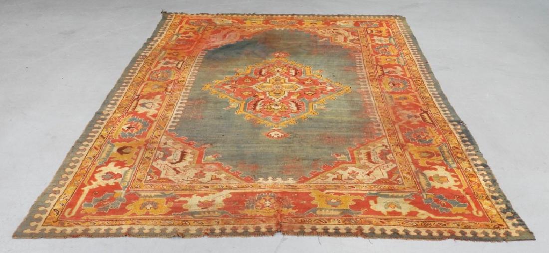 C.1900 Oriental Turkish Oushak Carpet Rug: TURKEY, CIRCA 1900 An antique Oriental Turkish Oushak carpet. The carpet is decorated with a central red and yellow geometric medallion over a blue ground with a red and yellow geometric border. Dimen