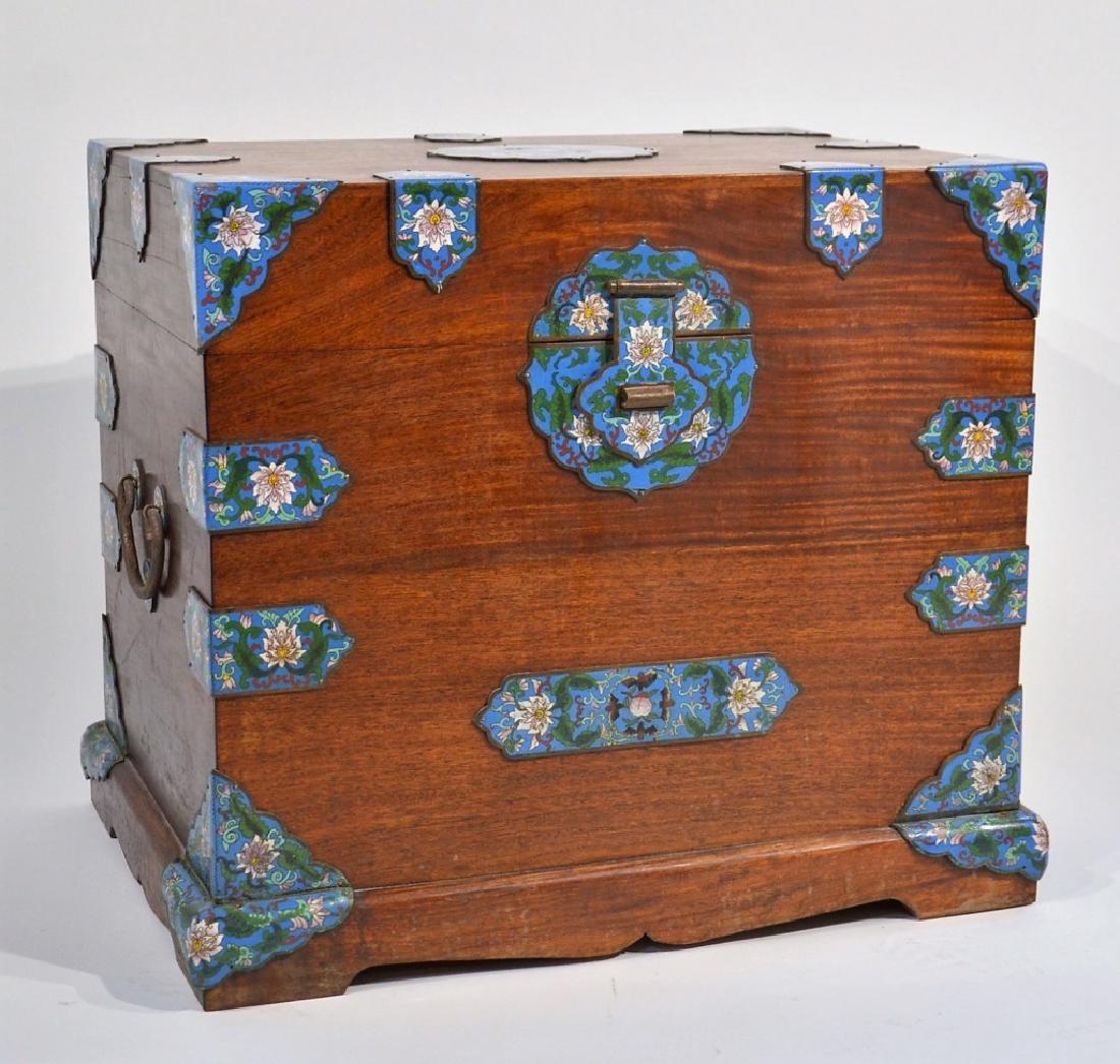 Chinese Cloisonne Camphor Wood Chest: CHINA, EARLY 20TH CENTURY A Chinese Cloisonne camphor wood chest. The chest is decorated with polychrome Cloisonne hardware of lotus flowers and tendrils with iron handles. Dimensions : 24 1/2" by 17 