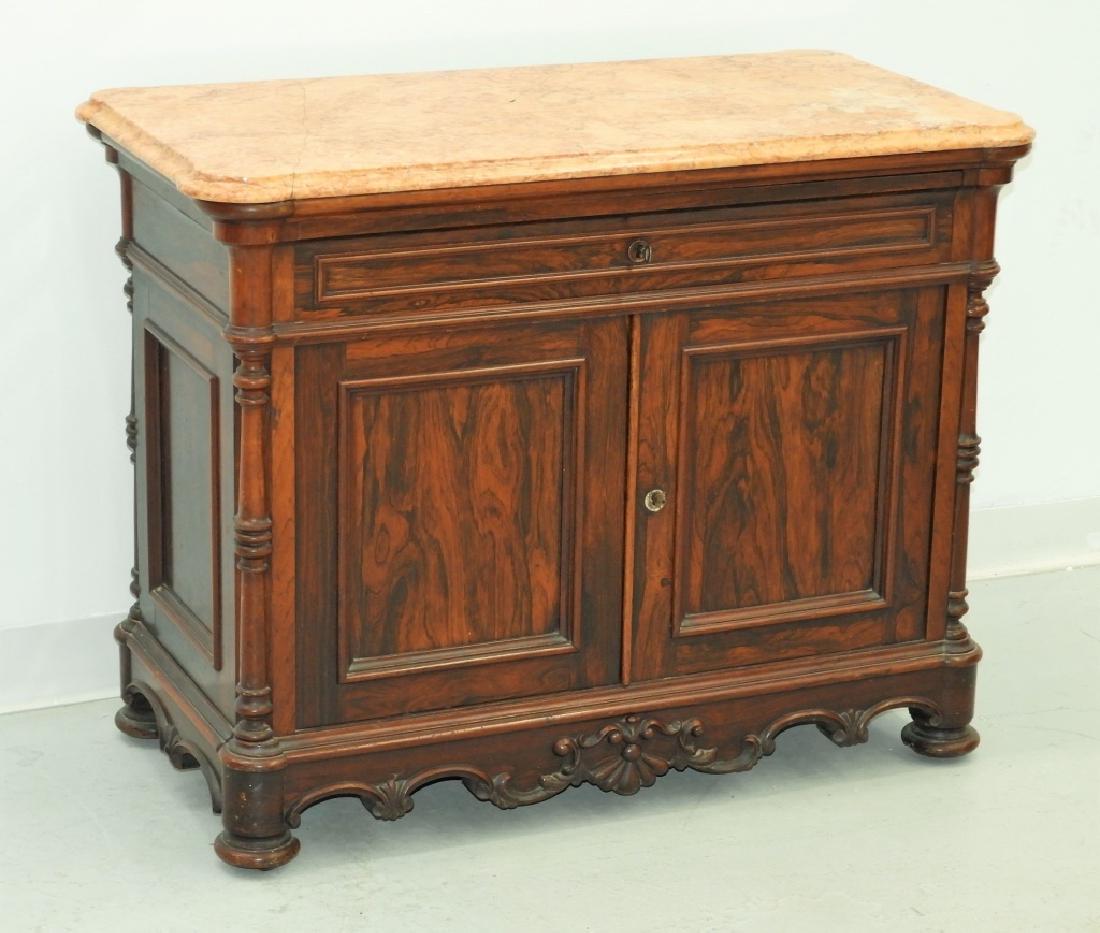 19C. French Rococo Rosewood Marble Top Commode: France, Late 19th Century Shapely apron with center shell crest and carved corner columns with inset panels, finished back. Carved rosewood, rouge marble 36" by 19" by 28"