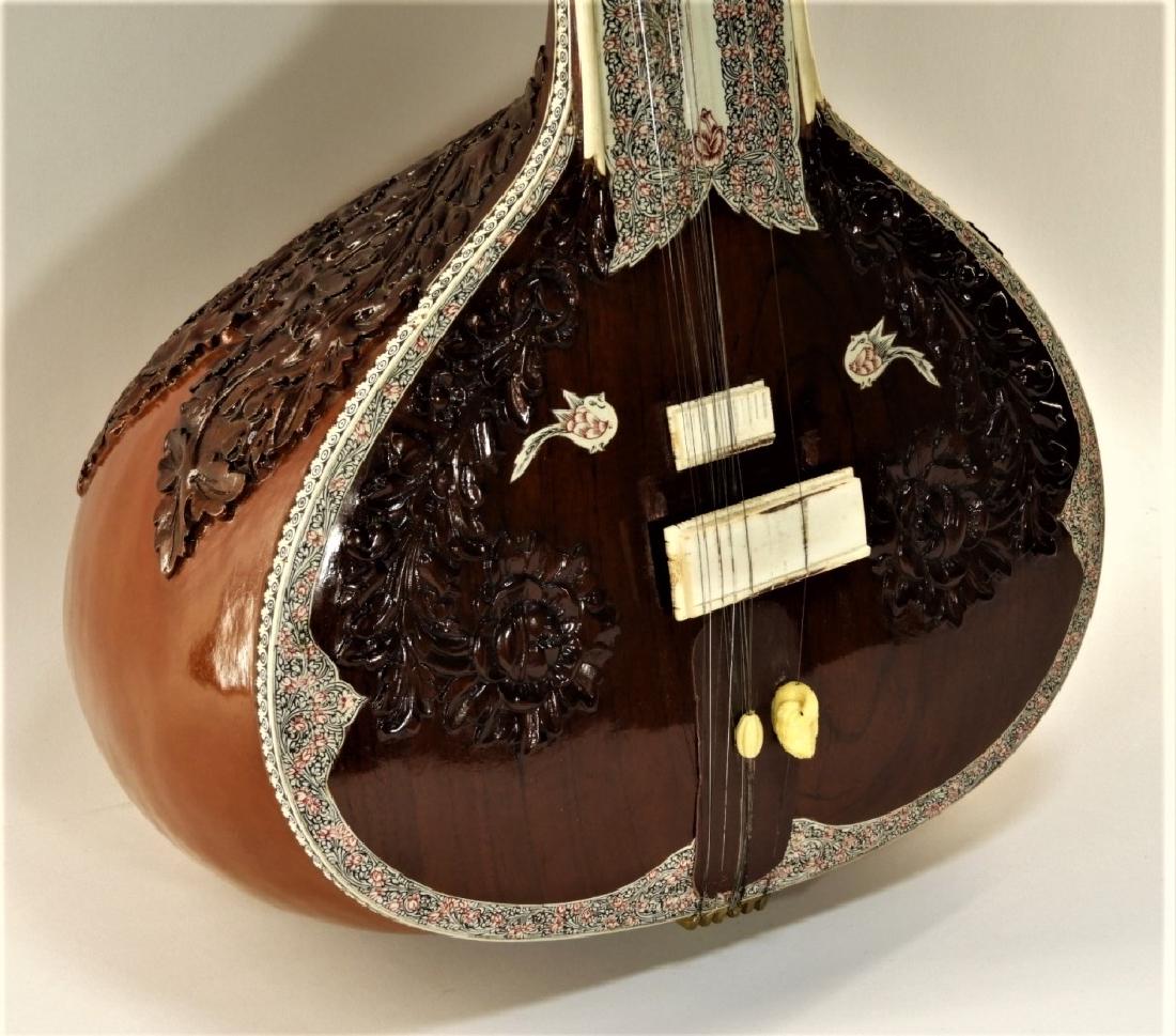 Indian Bina 17 String Carved Inlaid Bone Sitar: India,20th Century Decorated with relief carved flowers and inlaid tendril, flower, and bird designs. Marked with tag on fretboard "BINA Music Stores" and "Made in India". From a Cape Cod, Massachuset