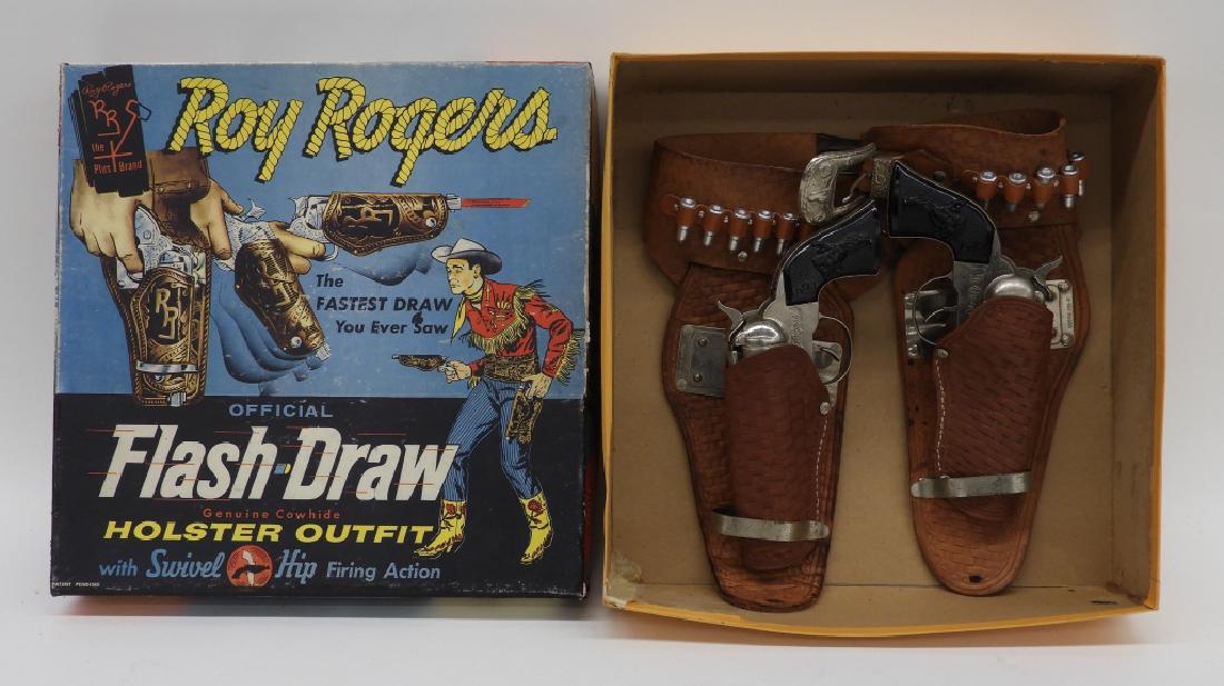 Roy Rogers Flash Drawer Holster Cap Gun Outfit Set: United States,Mid 20th Century A Roy Rogers official Flash Draw genuine cowhide holster outfit with swivel hip firing action. Tooled leather basket weave design holsters outfitted with twelve plastic