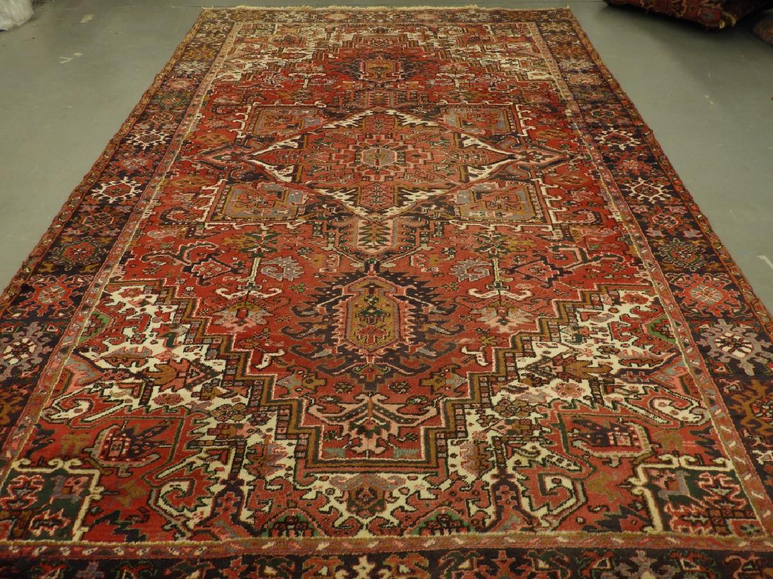 C.1940 Persian Middle Eastern Heriz Carpet Rug: ,Persia,Circa 1940 Central red field with allover geometric floral tendril pattern within a stylized floral border. Wool,14'11" x 9'8", From a Cape Cod, Massachusetts estate.