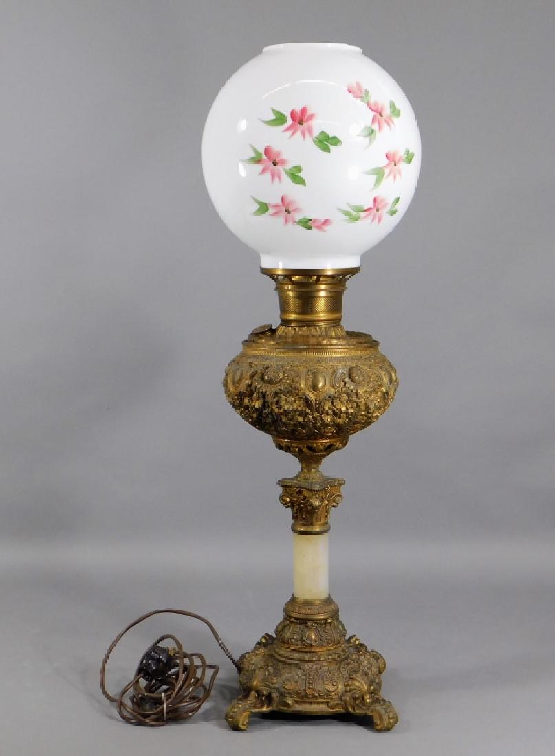 19C. American Victorian Gilt Banquet Oil Lamp: ,United States,Late 19th Century Repousse decorated with an allover acanthus leaf and floral motif embellished with an alabaster shaft supporting a floral painted globe shade. Cast metal,27 3/4" tall 