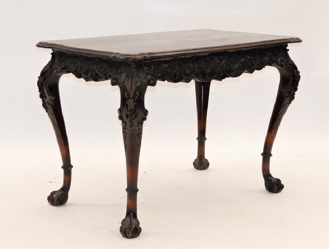 European Carved Walnut Rococo Library Table: Europe,19th Century Scalloped top over a heavily carved apron with north wind faces front and back with acanthus leaf drapes over four heavily carved legs with shell carved knees terminating into ball