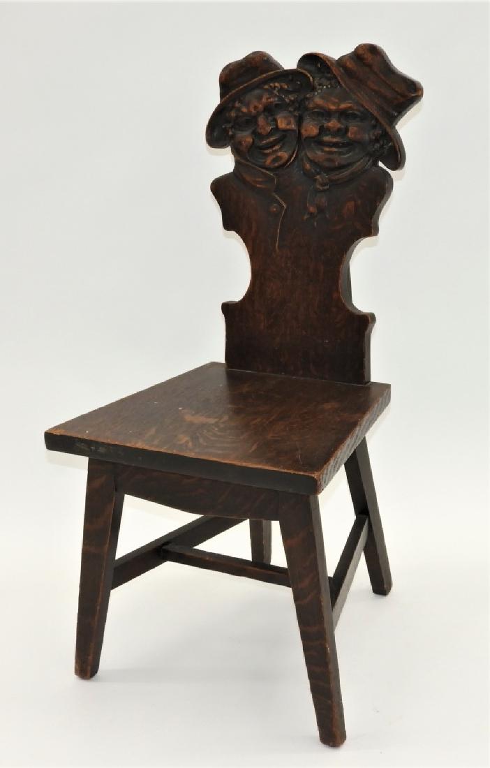 Stomps Burkhardt Co Oak Golliwog Figural Chair: Ohio,Circa 1900 Carved with two figures with exaggerated expressions as their garb turns into chair back over a flat plank seat upon splayed legs. Oak,37 1/2" t x 18" w x x19" d, Label on bottom of se