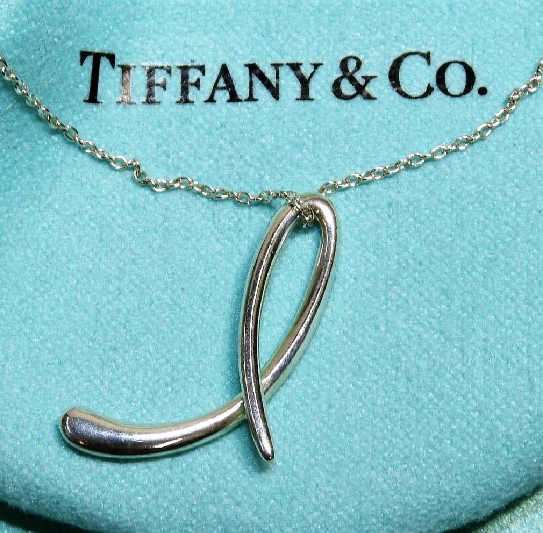 Tiffany & Co. Elsa Peretti Sterling "L" Necklace: Tiffany & Co. United States,Contemporary Elsa Peretti collection letter "L" pendant supported by a delicate sterling chain. 925 silver,20" chain,Pendent approx 1" long Marked "Tiffany & Co. 925" on ch