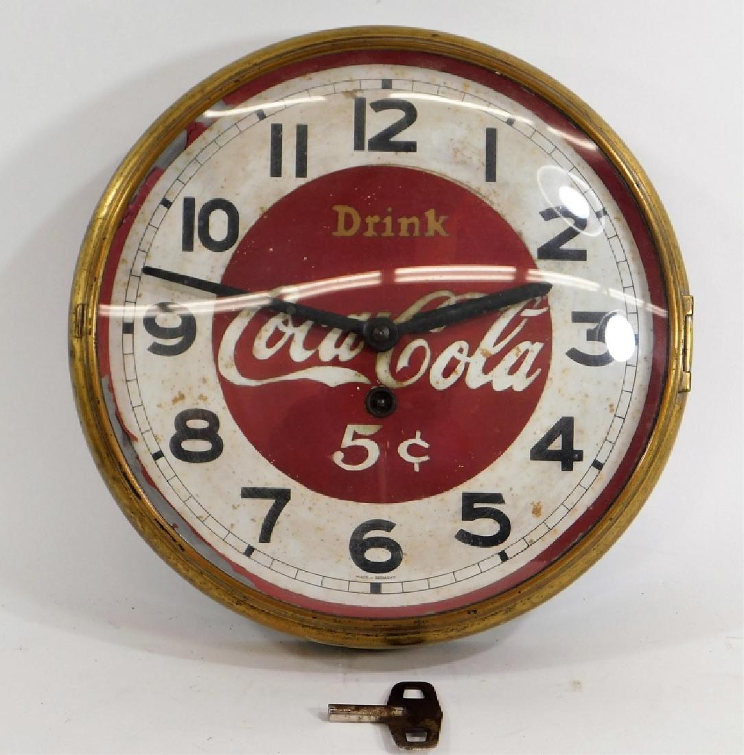 Coca-Cola Key Wind Advertising Wall Clock: United States,20th CenturySmall round clock with bubble glass and reads "Drink Coca-Cola 5 Cents".Metal and glass,10 3/4" diameter,From the collection of Russell Buteau, Millville, Massachusetts. Life
