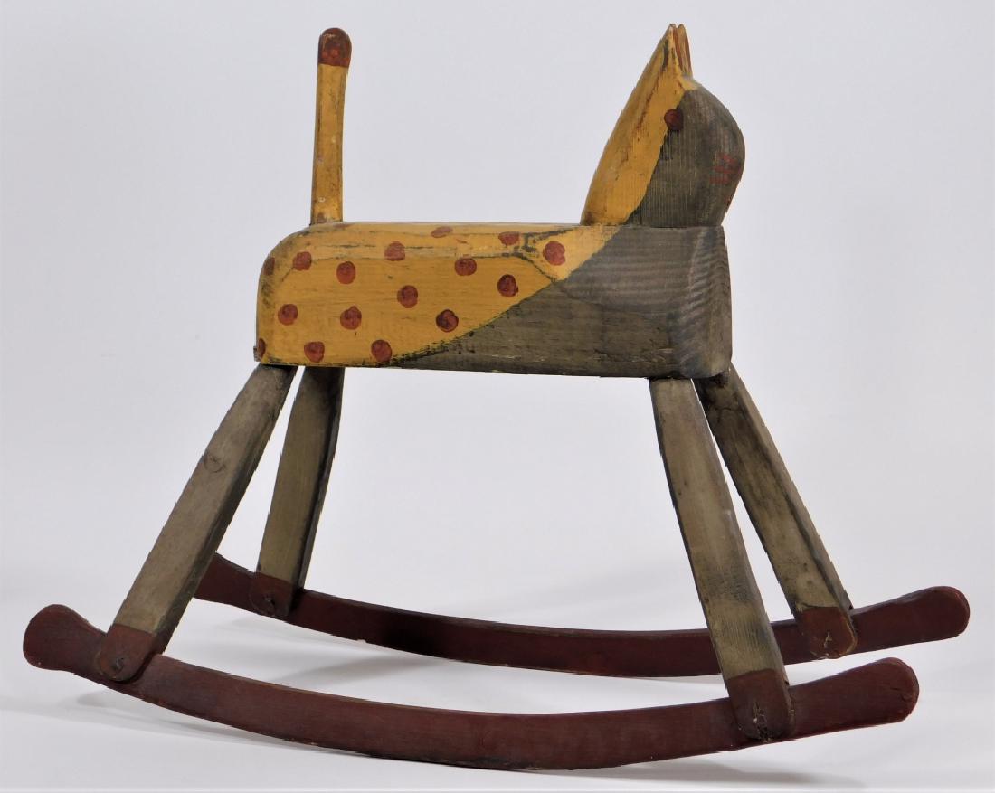 20C American Primitive Folk Art Rocking Cat Toy: United States,20th Century Simplistically carved and finished in yellow paint with red spots, whiskers, mouth, and eyes. Wood,17" tall x 22 3/4" long x 8 1/4" wide, From the collection of a Newport, R