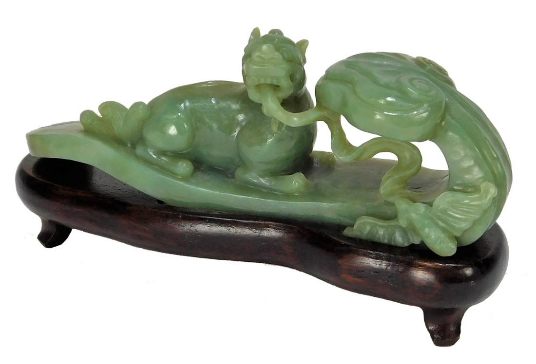 Chinese Carved Jadeite Ruyi Scepter Foo Dog Statue: ,China,Qing Dynasty Carved green jadeite ruyi scepter with figural recumbent foo dog with exposed long tongue and bat. Hardstone, wood,Hardstone 2 5/8" x 6 1/2",Overall 3 5'8" x 7" From the collection