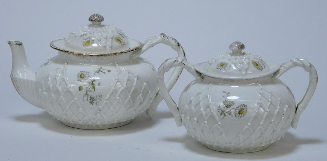2PC Lotus Ware Porcelain Teapot & Sugar Bowl Set: ,United States,Early 20th Century Includes a teapot and matching sugar bowl with delicate raised fishnet design, enameled daisy flowers, and speckled gilt accents. Porcelain,Smallest 4 1/4" x 5 3/4",L