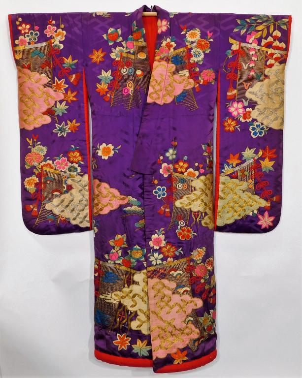 Japanese Edo Period Purple and Gold Floral Kimono: Japan,Circa 1830 Hand woven rich purple silk satin damask kimono with striking gold couching and lush with heavily embroidered designs of flowers and clouds. 52 1/2" wingspan x 25 1/4" across x 65 1/2