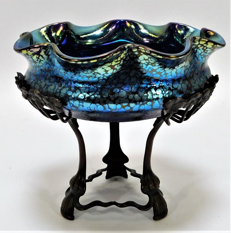 Blue Papillon Bohemian Art Glass Compote: Bohemia,20th Century Loetz style blue papillon frilled glass bowl exterior with oil slick interior resting atop a floral metal stand and supported by three shapely legs. Glass, metal,6 1/4" x 7" dia.,