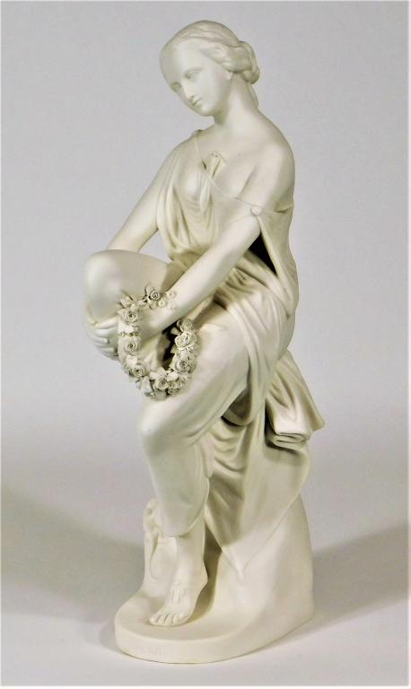 Minton Parian Porcelain Classical Model of Lalage: England,Late 19th Century Modelled by John Bell depicting the woman of Horace's poetry seated on a tree trunk in diaphanous drapery with exposed breast holding a floral wreath. Porcelain,15 3/4" x 6"