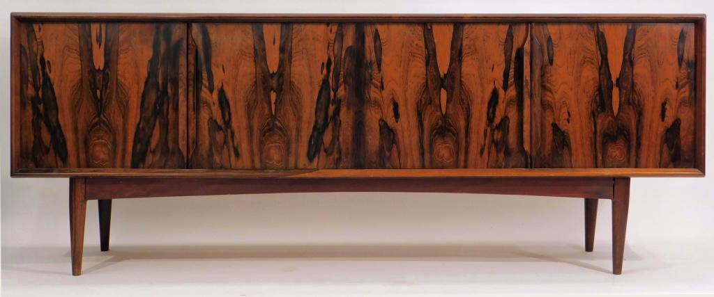 Danish Ib Kofod-Larsen Rosewood Sideboard: Denmark,20th Century Rectangular top over four doors with distinguished grain, opening to reveal three drawers and two shelves, supported by four simple legs. Brazilian Rosewood,32" t x 83" w x 20" d,