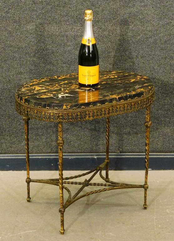 Attrib. Oscar Bach Wrought Iron Marble Top Table: United States,Late 19th- Early 20th Oval black and tan variegated marble top over pierced ornate apron supported by four thin twisted tapered legs with decorative cross stretcher. Metal, marble,22" t 