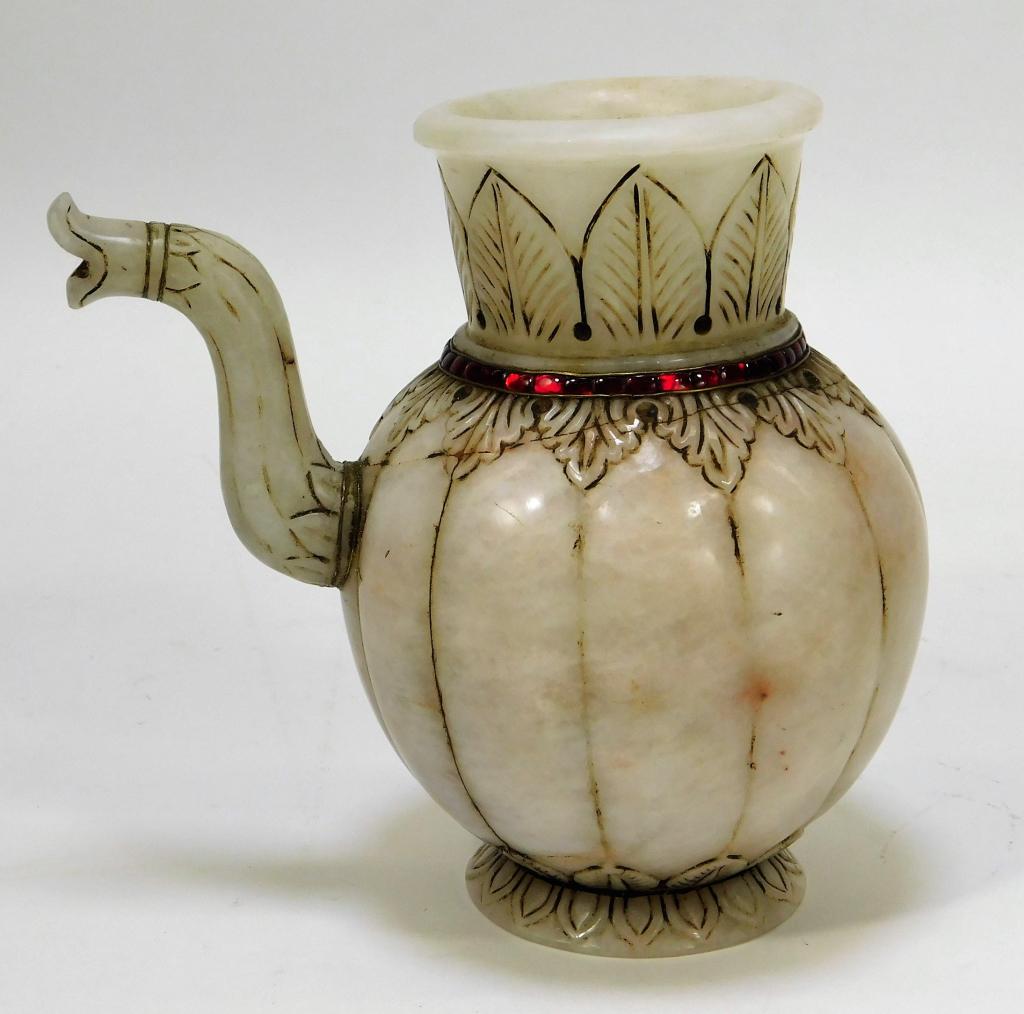 Antique Indian Carved Jadeite Teapot: India,19th Century Round bodied teapot decorated with intricate leaf patterns and red glass around the neck. The bottom is decorated with a lotus flower. White jadeite, glass,6" x 7" dia., From the co
