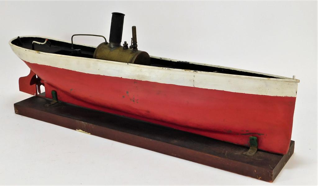 Antique German Pressed Steel Steam Powered Boat: Germany,Early 20th Century Red and white painted boat with yellow interior housing a miniature steam engine on a simple wood base. Boat exhibits scratching and losses to paint in exterior, boiler not 