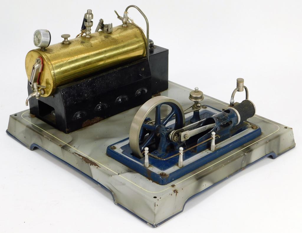 Attr. Doll Antique Steam Engine: Germany,Early 20th Century Horizontal brass boiler missing burners with single fly wheel mounted on a metal base finished to appear smoke covered. Metal,7" t x 12" w x 10" d, Marked "Made in Germany U