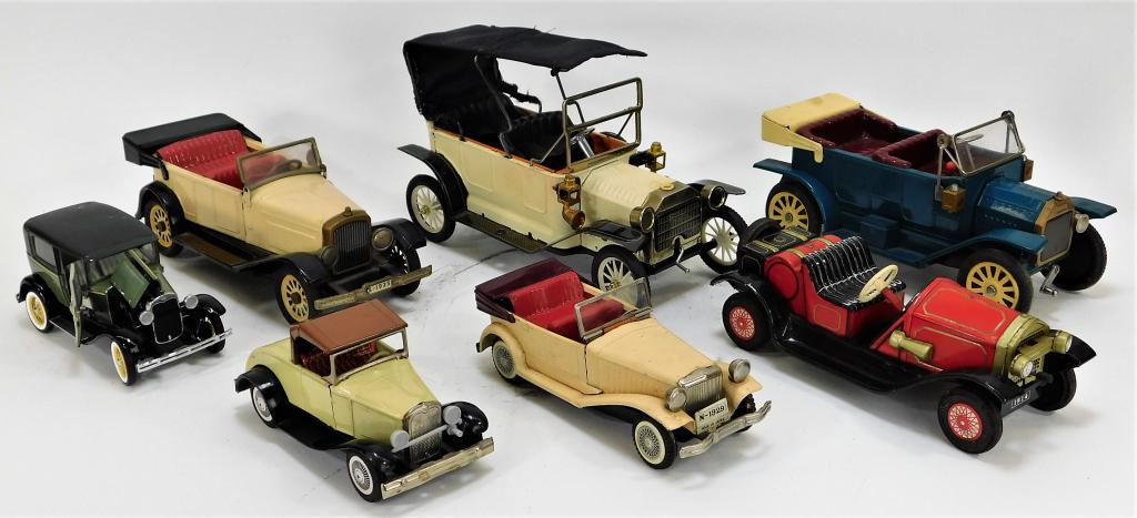 7PC Japanese and American Toy Car Group: Japan, United States,Early 20th Century Includes three cream colored cars, one large battery powered car with fabric roof, one Cragstan red car, one blue friction car, and one Franklin Mint 1930 Ford 