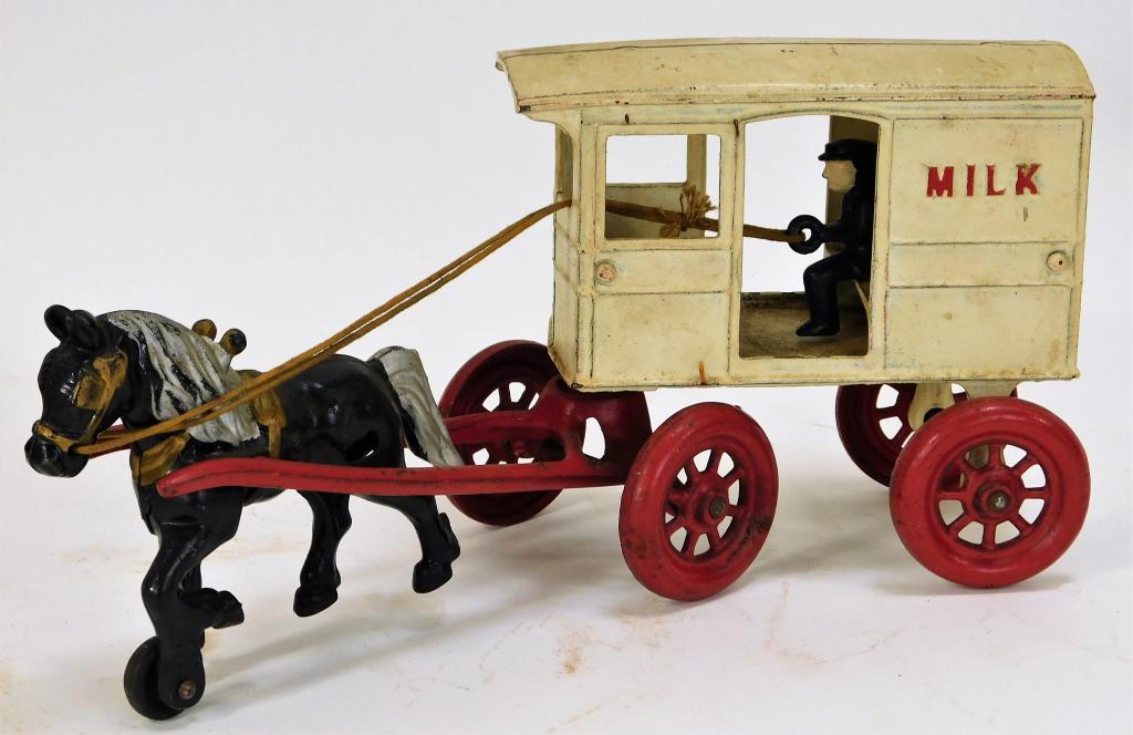 Antique Kenton Cast Iron Milk Truck: United States,Early 20th Century Cold painted white and red milk truck with driver and black horse, exhibits pink staining to top of wagon with minor scratches and paint loss. Cast iron,6" t x 3 3/4" 