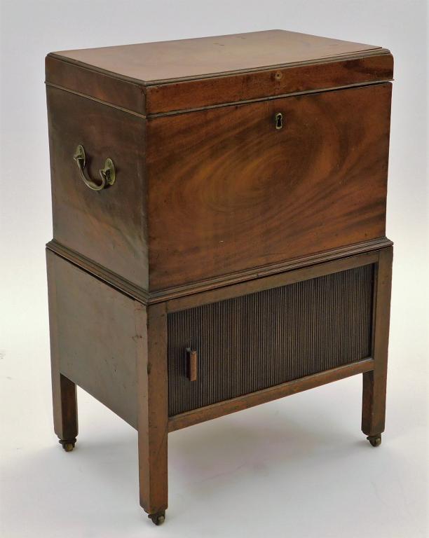 George III Flame Mahogany Wine Liquor Cellarette: England,Circa 1810 Two piece cellarette with flame mahogany case with six compartments and brass hardware over a horizontal tambour door with Marlboro leg stand. Wood,29" t x 20" w x 13" d, From the c