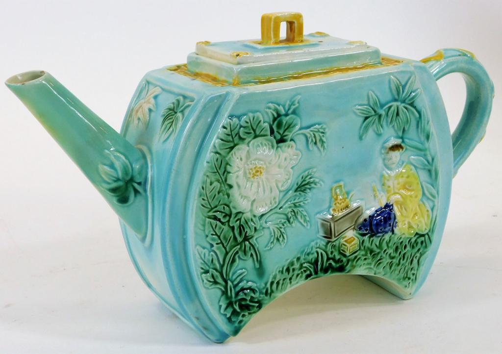 Attr. George Jones English Majolica Asiatic Teapot: England,Late 19th Century Shapely aesthetic teapot decorated with an Asian woman drinking tea beneath white flowers over a powder blue glaze. Pottery,5 3/4" t x 10" w x 3 1/8" d, Marked "T" on bottom.