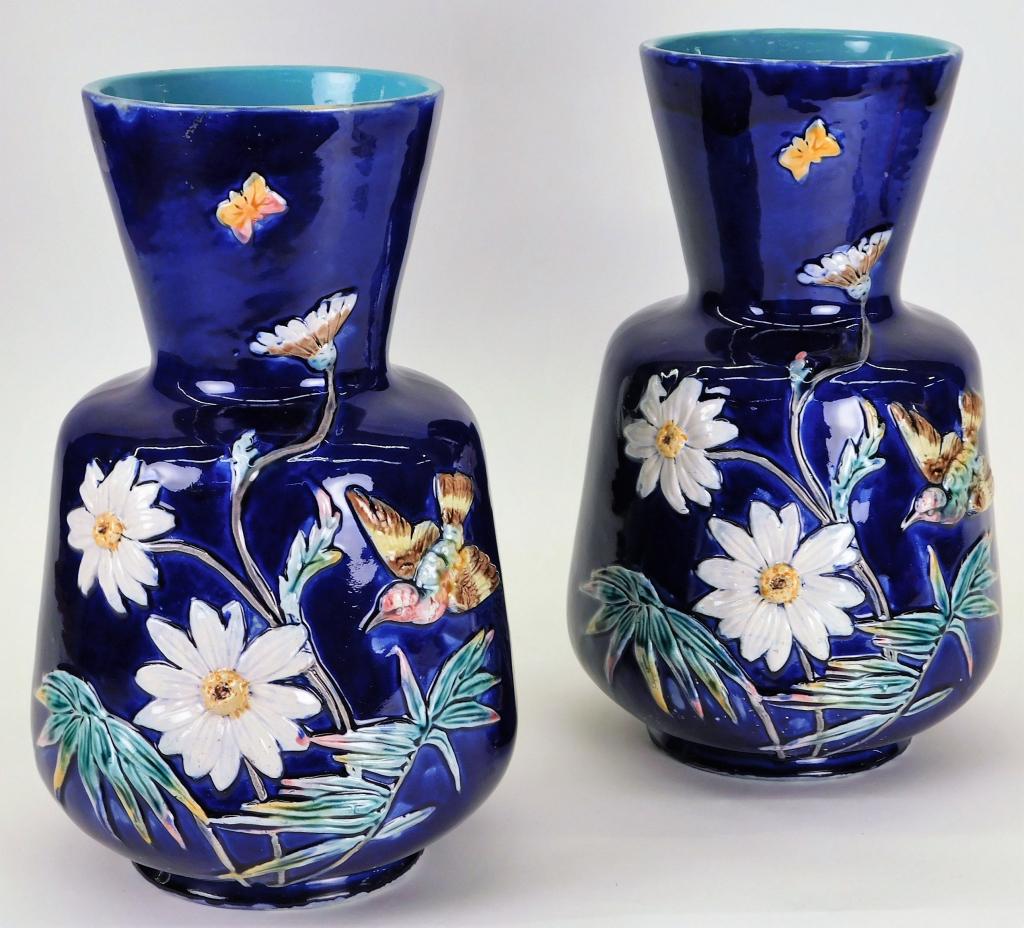 PR English Aesthetic Majolica Daisy Vases: England,Early 20th Century Pinch neck vases with applied white daisies and butterflies over a striking cobalt blue ground. Pottery,12" x 7" dia., From the collection of a Newport, Rhode Island lady.