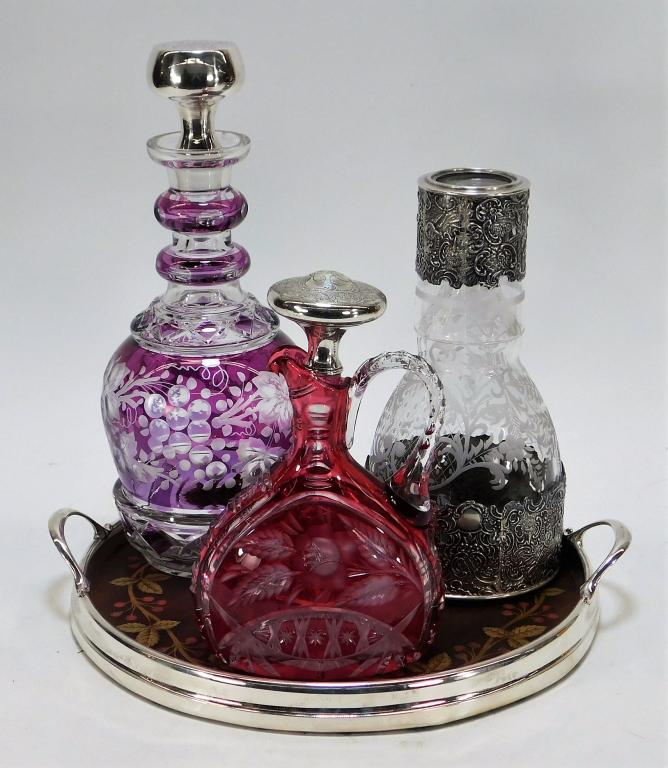 5PC Silver Overlay Glass Decanter Tray Vanity Set: United States,Early 20th Century Includes one matching decanter and glass set decorated with musicians and neoclassical scenes with etched flowers, one red cut glass handled decanter decorated with ro