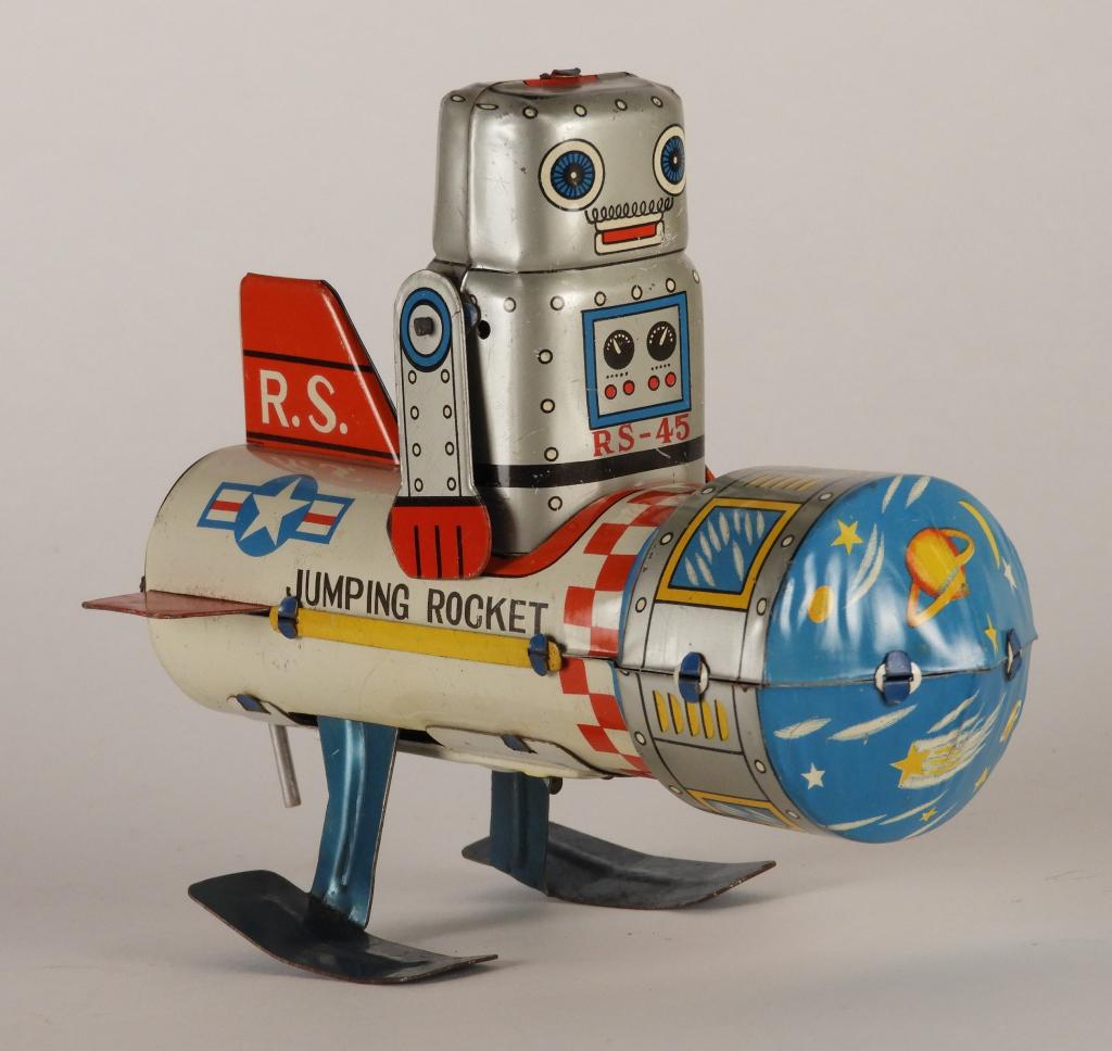 Japanese Yoneya Tin Jumping Rocket Robot Toy: Japan,Circa 1960 C8 with light signs of play wear, light scratching scattered throughout with moderate scratches to underside from use over time, working condition. 5" x 6" x 3"
