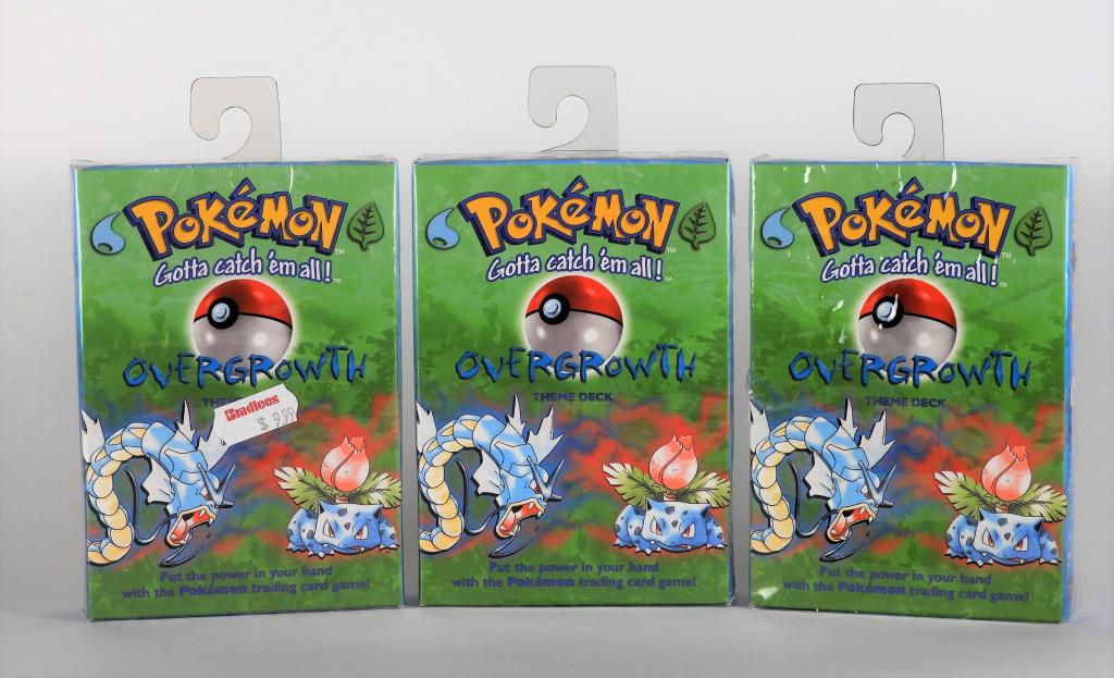 3PC 1999 Pokemon Overgrowth TCG Theme Deck Group: United States,1999 Group includes three factory sealed 1999 Wizards of the Coast Pokemon Overgrowth theme decks, one with tear to cellophane and cut to box side most likely from a box knife when opene
