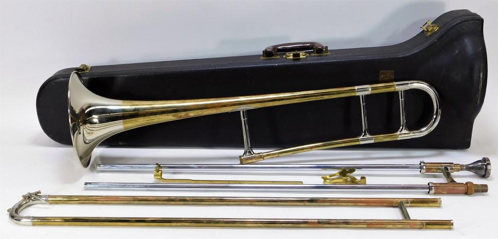 F. E. Olds & Son Trombone with Case: United States,20th Century Fine trombone includes mouthpiece and lyre attachment with a hard case. Trombone 46" l w/ 7 1/4" dia bell,Case 36" t x 11" w x 8 1/4" d, Brass Outside of case marked "Olds" 