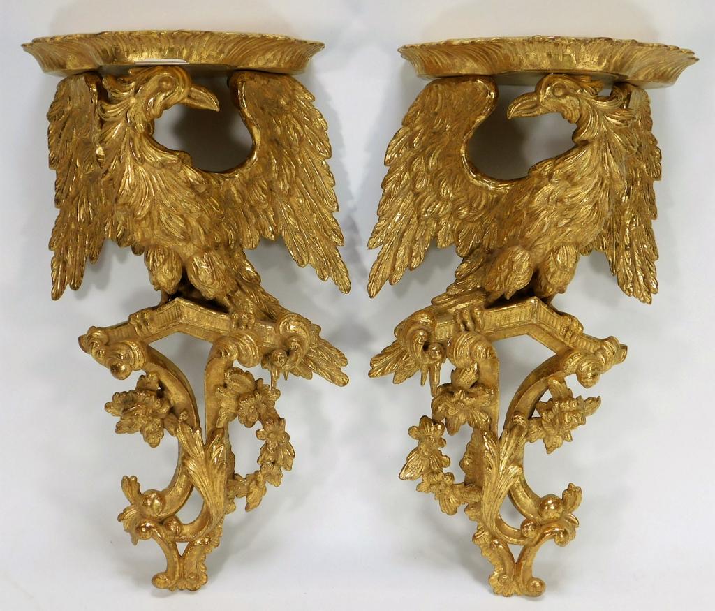 PR Gilt Carved Wood Eagle Shelves: Europe,Late 19th- Early 20th Century Opposing pair of eagles with spread wings perched on an acanthus leaf and flower decorated base. 19 1/2" x 10 1/2",7" off the wall, Wood, gesso From the collection