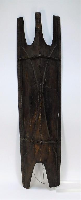 African Tribal Carved Wood Shield: Africa,20th Century Carved shield with three prongs to the top and two to the bottom decorated with geometric shapes and figures. 35" t x 8 1/4",, Wood From the collection of an East Providence, Rhode