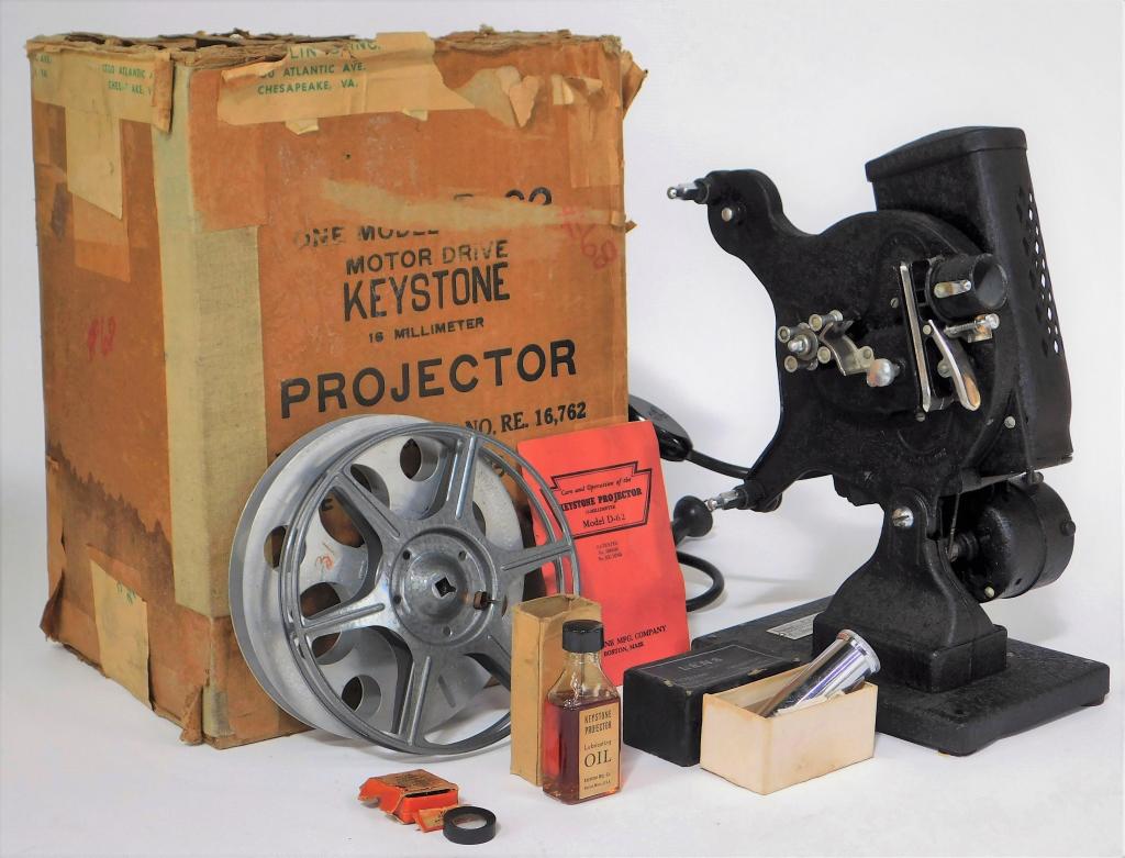 Keystone Model D-62 16mm Movie Projector: Keystone Model D-62 16mm movie projector in original box. Includes manual, reels, oil and other accessories as shown.