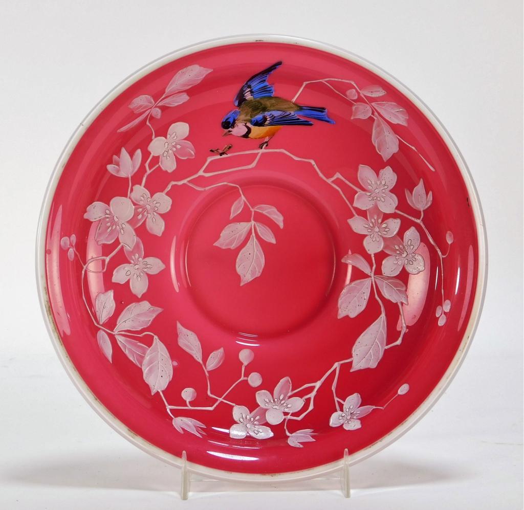 Attrib. Thomas Webb Peachblow Enamel Bird Bowl: Thomas Webb,England,1804-1969 With a colorful hand painted bluebird atop a white enamel flower and foliate branch on a rosy red colored shallow bowl with white and clear trimmed rim. 9" x 2", Unsigned