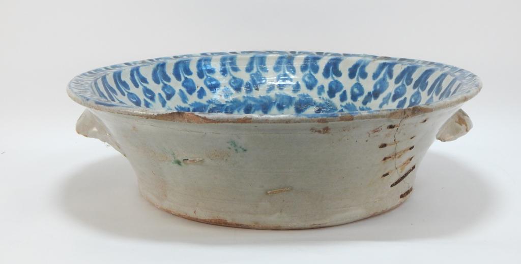 18C. Large Delft Bird Wash Basin Staple Repair: ,Holland,18th Century Large flared rim basin with repeated floral pattern with large bird on branch painting in center. The exterior with a pair of handles in allover white glaze with noticeable old s