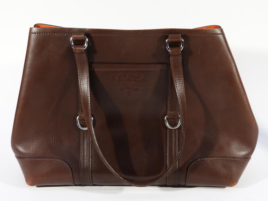 Lady's brown Leather Prada Tote Purse Handbag: ,Italy,Contemporary Brown leather with Prada logo, orange interior, includes felt storage bag.12t x 16"w x 6"d,,Leather