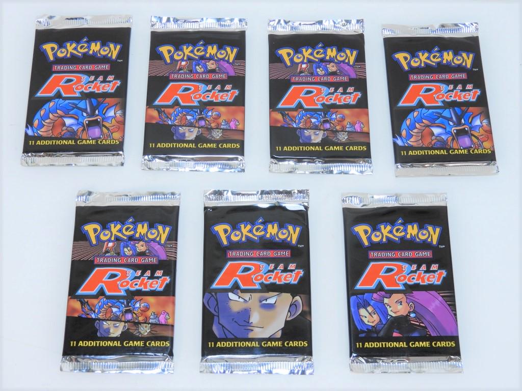 7PC 2000 Pokemon Team Rocket Unl. Booster Packs: United States,1999 Group includes seven factory sealed 1999 Pokemon Team Rocket Unlimited trading card booster packs. All with light shelf wear as expected from age and handling. Factory sealed, pleas