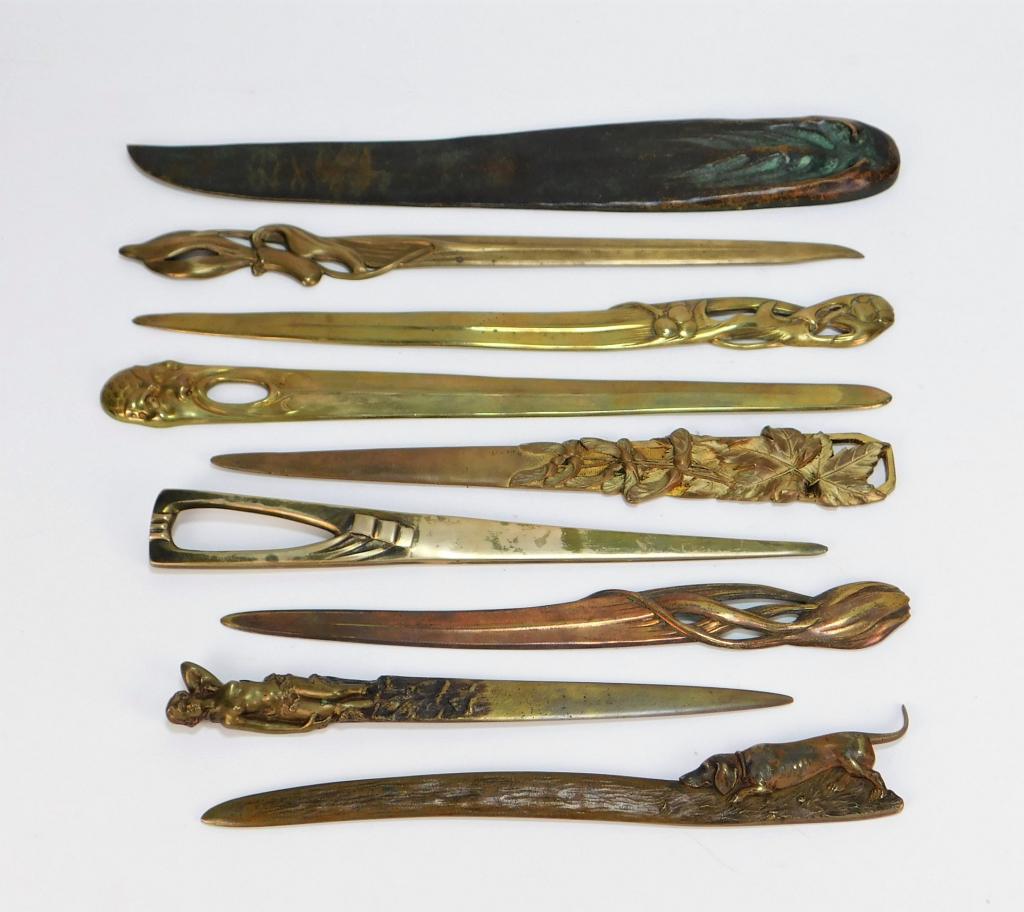 9PC Art Nouveau Bronze and Brass Letter Openers: Germany, Austria 20th Century Includes three stylized brass flower letter openers, a maple leaf opener, an angular opener, a figural opener of an open mouth face, a nude woman, a bronze bloodhound, an