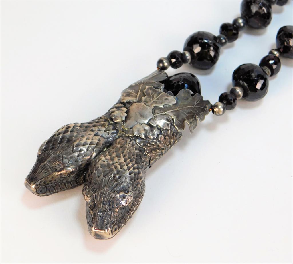 Victorian Sterling Silver Ruby Serpentine Necklace: 19th Century Ruby and sterling silver beads strung on copper wire with double headed snake pendant surrounded by leaves. Length 23",Pendant size 3 1/4" x 2",Sterling silver, copper, ruby ,From the col