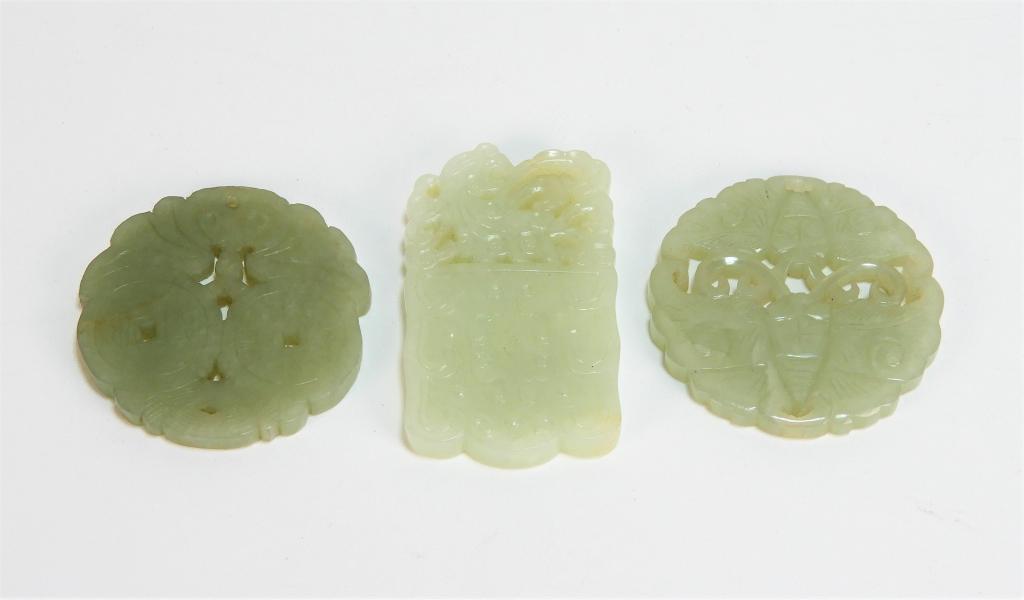 3 Chinese Carved Celadon Hardstone Amulets: China Qing Dynasty Includes a double sided carved butterfly amulet, a coin and bat amulet, and a tendril design plaque amulet. Smallest 2 1/8" dia.,Largest 2 5/8" x 1 5/8",Hardstone ,From the collecti