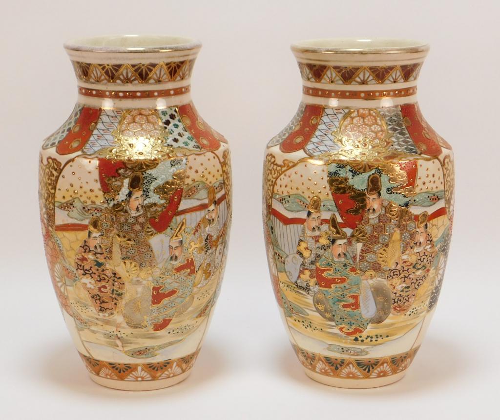 PR Japanese Gilded Satsuma Court Scene Vases: Japan Meiji Period Rich red and blue panels with various intricate patterns frame two court scene cartouches embellished with gold gilding. 13 1/4" x 6 3/4" dia.,,Pottery Both signed on bottom.,From t