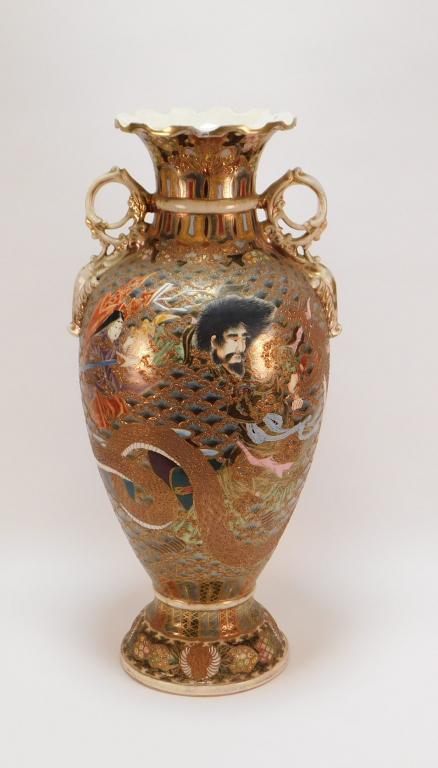 LG Gilded Japanese Satsuma Handled Vase: Japan Meiji Period Baluster form vase with dynamic depictions of a woman holding a fan while a man fights a fierce dragon on one side with a cartouche of an elderly couple encased in a blue scale patt