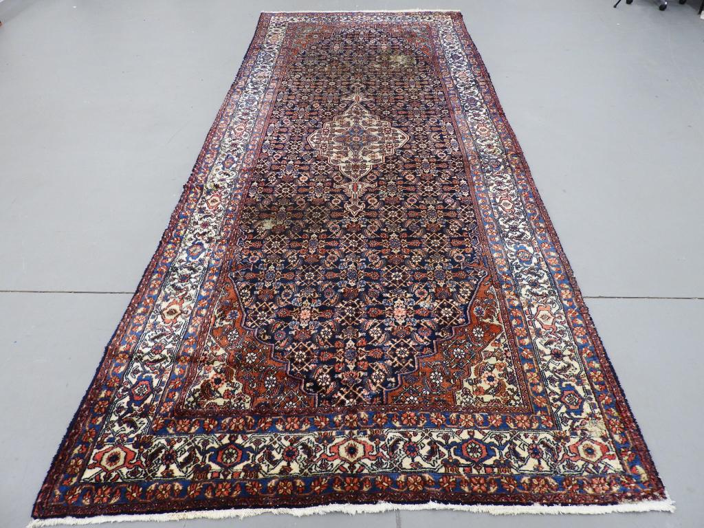 Circa 1920 Antique Persian Carpet Rug: Persia Circa 1920 Large ivory central medallion over a busy navy field surrounded by ivory and navy stylized floral borders. 16' 5" x 7' 1",,Wool ,From the collection of a Providence, Rhode Island gen