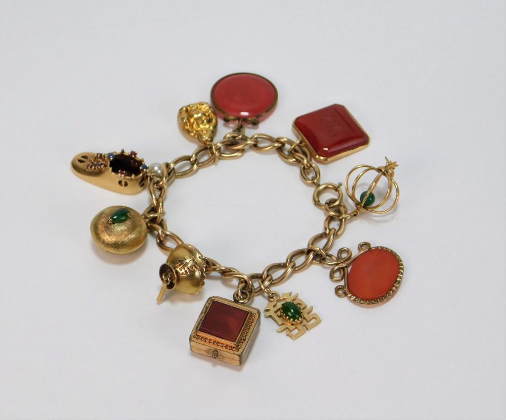 9K Gold Ruby Sapphire Hardstone Charm Bracelet: ,China,20th Century Chain link charm bracelet with two lantern charms with green hardstone, two calligraphy charms with green hardstone, three etched charms decorated with a lion and two portraits, a