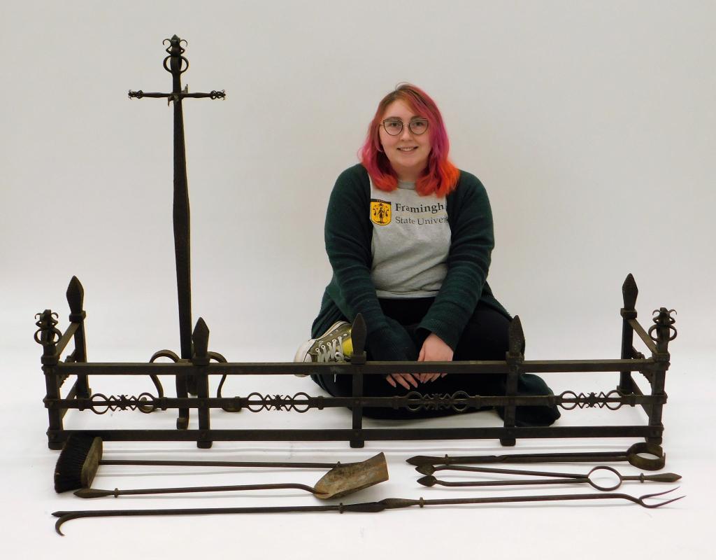 8PC Arts & Crafts Iron Fireplace Fender & Tools: United States,Early 20th Century Includes a fender with decorative finials and openwork design, a brush, a shuttle, a hooked poker, a pronged poker, two pairs of tongs, and caddy with matching design.