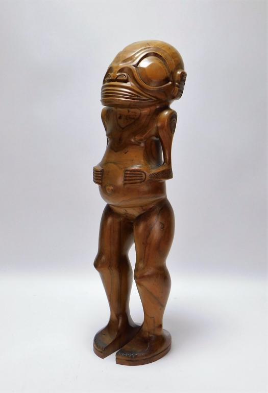 Balinese Wild Face Carved Wood Sculpture: Indonesia,20th Century Depicts a figure carved from hard figural wood with a wide face, short arms, bulging stomach, and thick legs decorated geometric lines and patterns. Wood,Approx. 22 1/2" t x 6" 