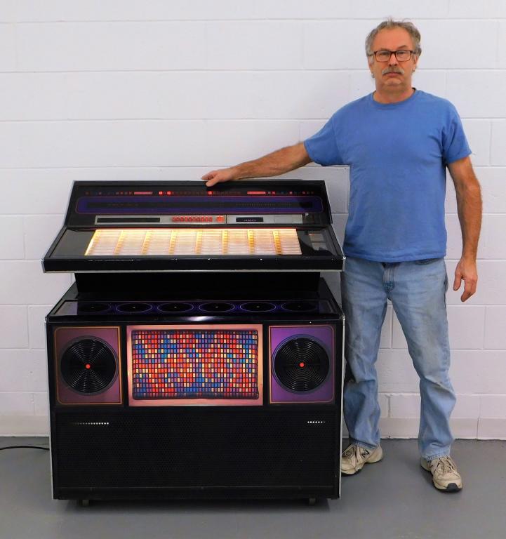 Rock-Ola Model 460 Jukebox: United States,Circa 1970 Lights up with red, white, and blue geometric mosaic pattern to front with speakers framed in purple with an integrated 48350-1A amplifier. Metal, plastic,45" t x 42" w x 24" 